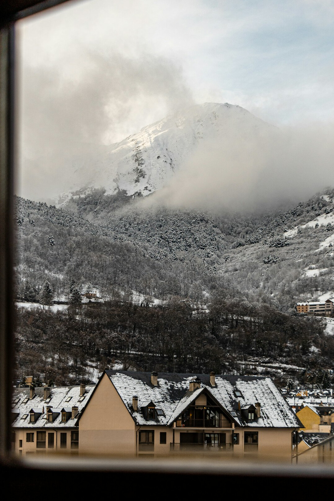 Luxury alpine hotel suite with a panoramic window overlooking snow-covered mountains