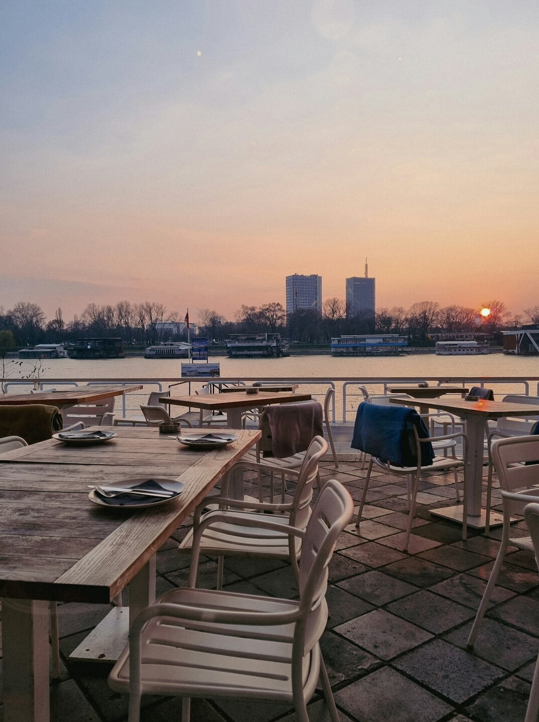 Elegant restaurant terrace with lake view set tables at golden hour